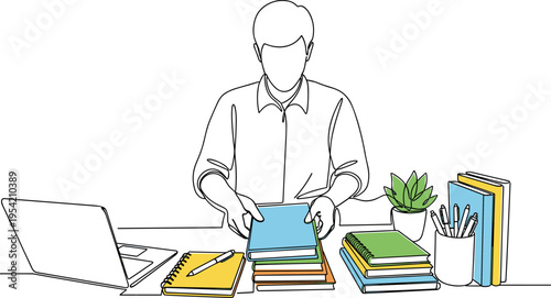 A man sits at a desk surrounded by books and a laptop