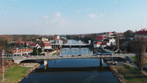 Aerial drone approach to road bridge over Elbe river with weir and town, Czech Republic