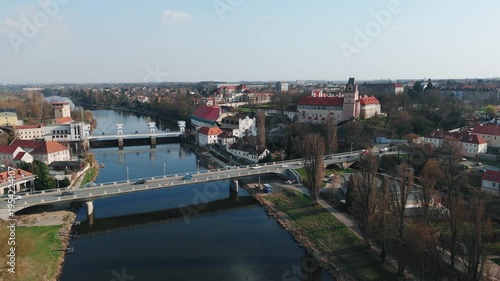 Aerial drone forward flight over Elbe river with road bridge, weir and Brandýs castle, Czech Republic