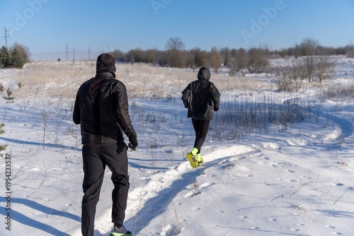 Wallpaper Mural Couple in black gear run on snowy path in open field. Torontodigital.ca