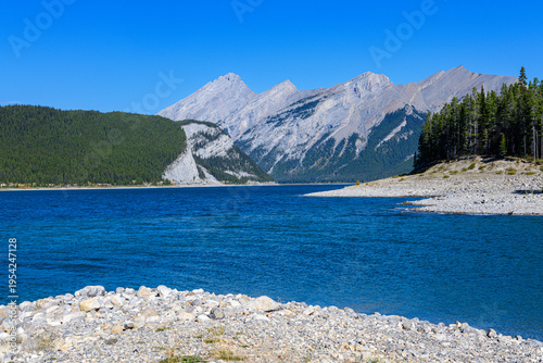 Bild auf Leinwand Gravel spit extends into turquoise waters of Spray Lakes, with imposing granite