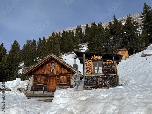 Old traditional swiss rural architecture and alpine livestock farms in the winter ambience of the alpine Swiss tourist resort Davos - Canton of Grisons, Switzerland (Kanton Graubünden, Schweiz)