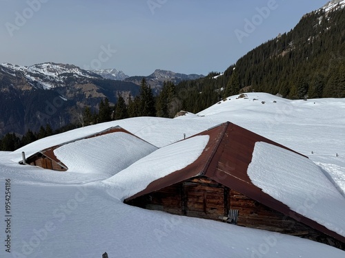 Old traditional swiss rural architecture and alpine livestock farms in the winter ambience of the alpine Swiss tourist resort Davos - Canton of Grisons, Switzerland (Kanton Graubünden, Schweiz)
