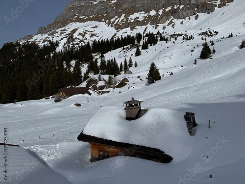 Old traditional swiss rural architecture and alpine livestock farms in the winter ambience of the alpine Swiss tourist resort Davos - Canton of Grisons, Switzerland (Kanton Graubünden, Schweiz)