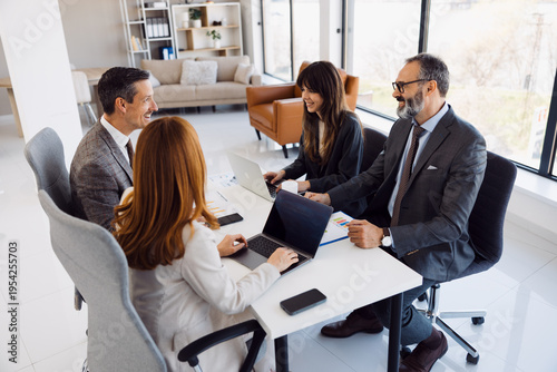 Fotografie Diverse group of four business professionals having a productive meeting around