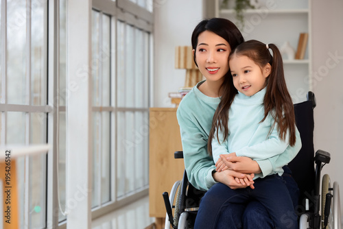 Young Asian mother in wheel...
