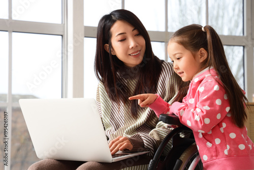 Young Asian mother in wheel...
