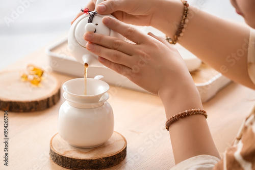Young woman pouring tea fro...