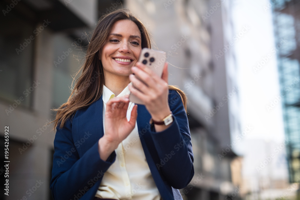 © SISMIZ - Happy businesswoman using smartphone on city street © SISMIZ - Happy businesswoman using smartphone on city street