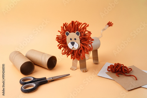 Lion craft made of toilet paper rolls orange yarn scissors brown cardboard. Creative recycling project for kindergarten school art classes kids education hobby blogs parenting workshops
