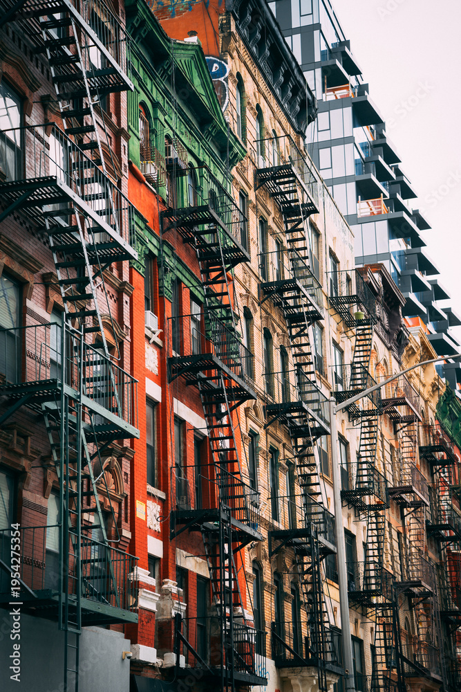 Obraz premium Fire escape stairs on building facade in New York, low angle view