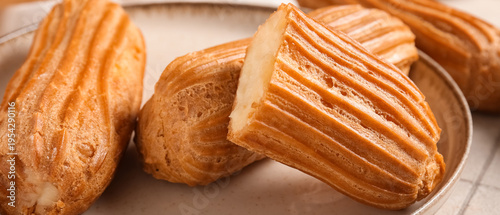 Plate with tasty eclairs, c...