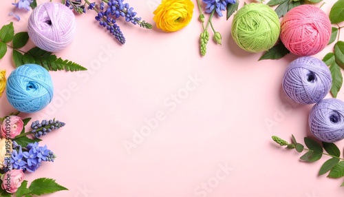 Yarn balls and flowers on pink background