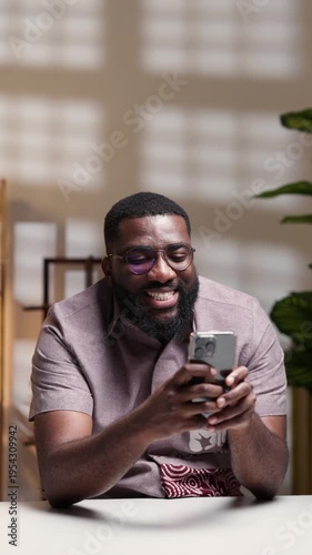 Vertical video, Happy African businessman using smartphone at home office, texting and using apps