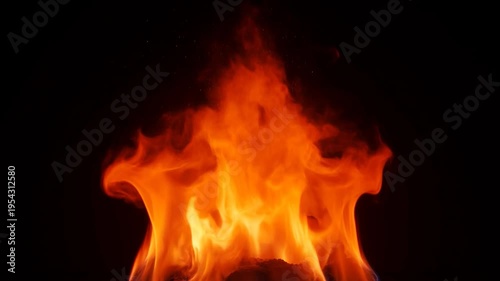 Burning red fire flame igniting and growing on a dark black background. Real beautiful bonfire blazing in slow motion