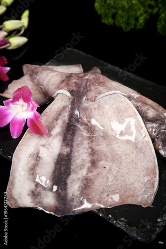 Fresh Raw Squid Seafood on Slate with Orchid Flower Garnish Studio Food Photography