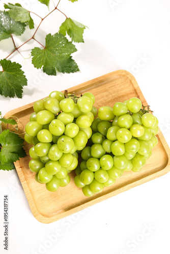 Fresh Green Grapes on Wooden Tray with Vine Leaves Studio Photography