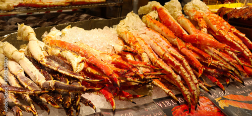 Frozen king crab legs on ice with price tags.