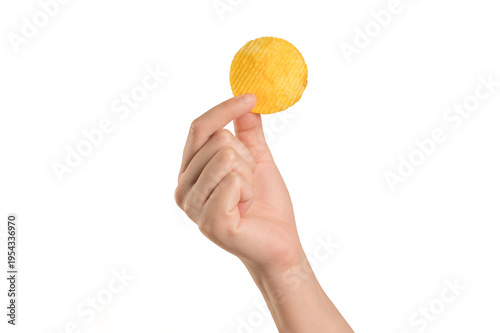  Hand holding  single corrugated yellow potato chip, isolated on  white background. Perfect for snack advertising, food branding, and delicious junk food .
