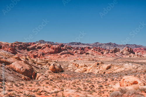 Tableau sur toile Rugged red rocks stretch under clear blue sky