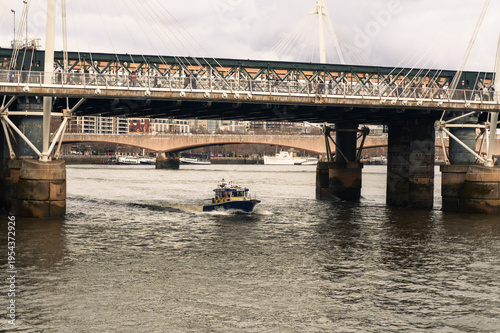 Canvas Print Metropolitan Police Patrol Boat Speeding Under the Golden Jubilee Bridges on the