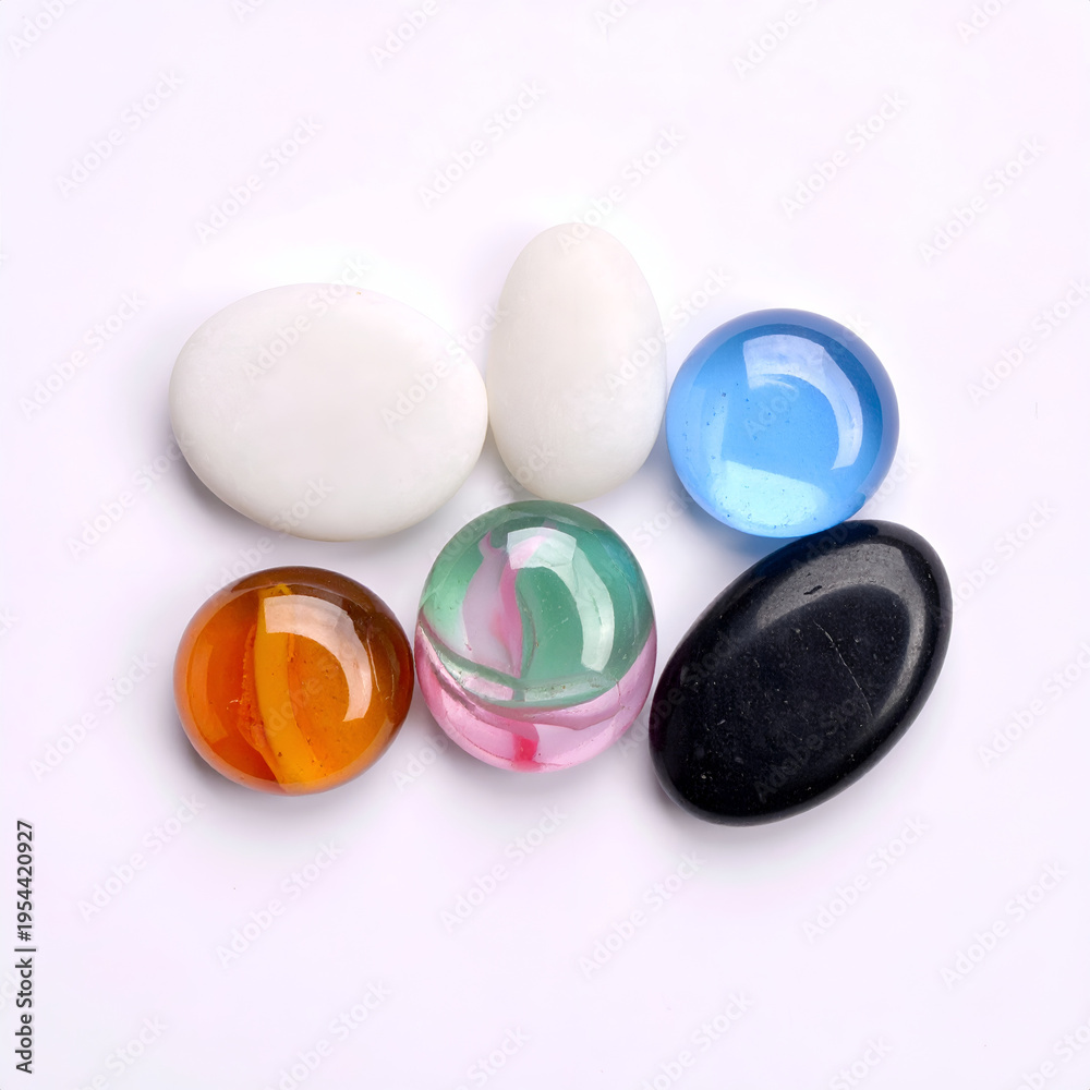 Fototapeta premium Colorful Round Glass Marbles and White Ovals on White Background