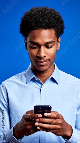 Smiling young man using smartphone.