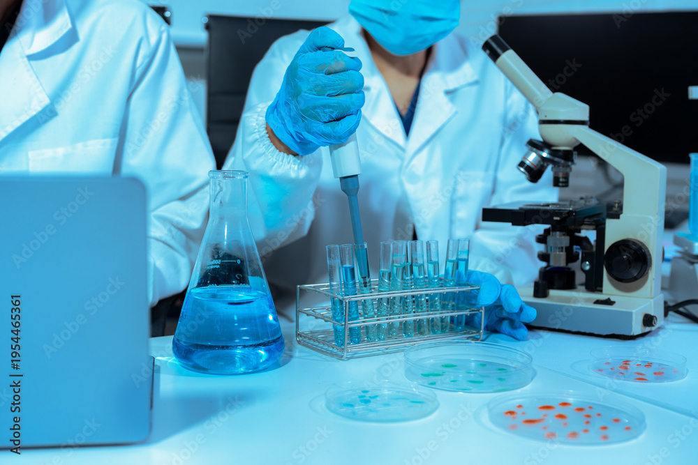 Fototapeta premium Team of biochemical research scientists working with a microscope for vaccine development
