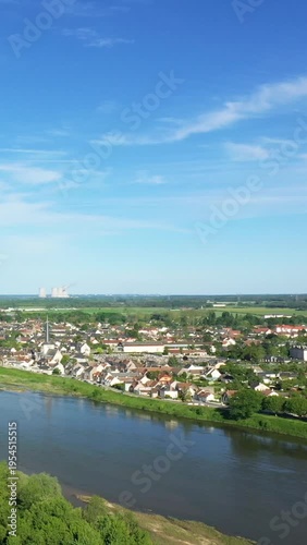 Scenic aerial view of Sully-sur-Loire with the Loire River in the foreground, traditional houses, and a clear blue sky. Peaceful rural landscape in central France.