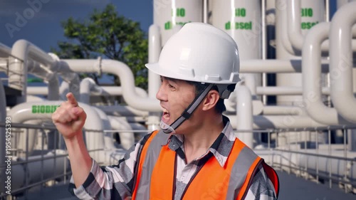 Close Up Side View Of Angry Asian Male Engineer With Safety Helmet Shouting At Someone While Standing at Biodiesel Production Facility