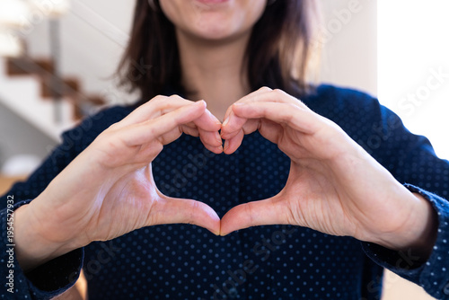 Woman making heart shape with hands expressing love