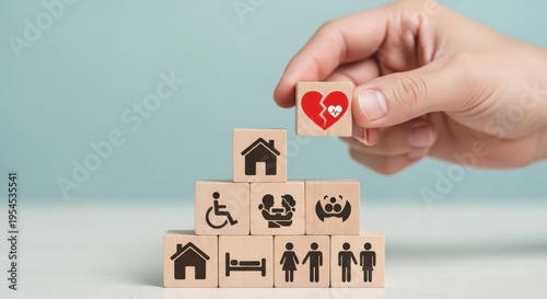 Hand placing wooden block with broken heart on stack aspect ratio 16 9