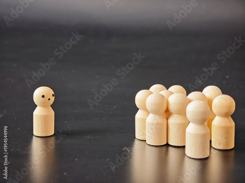 Wooden figures show individuality standing alone against group pressure in a simple setup