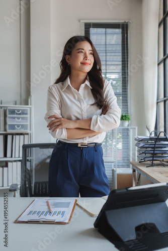 Confident businesswoman with arms crossed standing in office