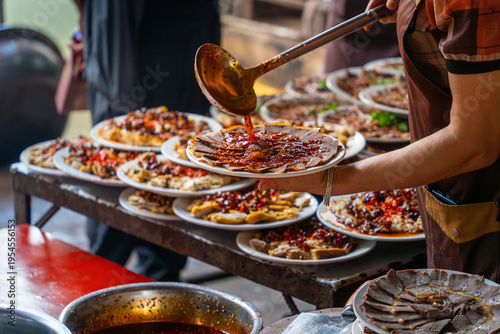 Tableau sur toile Street food vendor serving sauced sliced meat at market stall