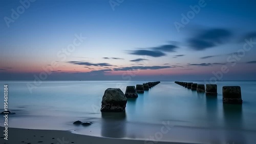 Serene Beach Scene with Breakwater at Sunset.