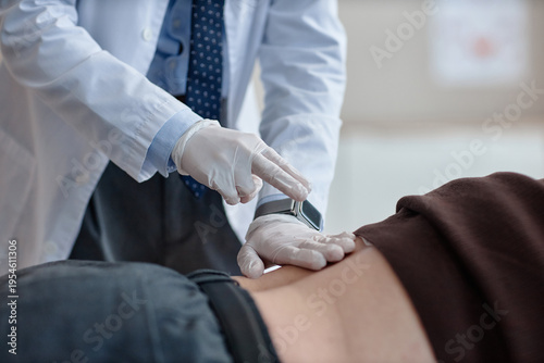 Foto Urologist wearing gloves examining lower back of adult man in clinical setting,