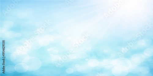 A beautiful bright blue summer sky features fluffy white clouds and radiant sunlight in a clear atmosphere for a stunning nature day