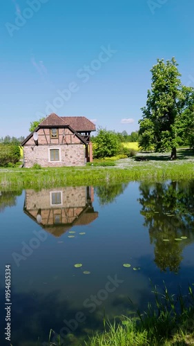Pleasure boat on a pond in a green park. Ancient castle against a blue sky with clouds. A popular holiday destination for Baltic tourists. Jaunmoku. Latvia