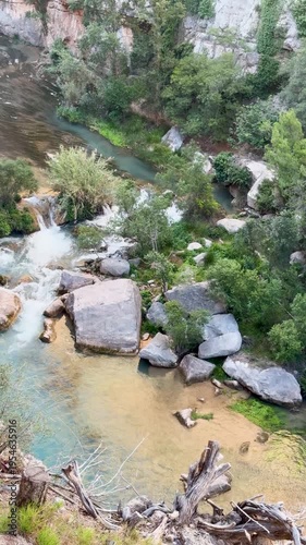 Rocky river scene with flowing water and lush vegetation on the banks. High quality 4k footage. Montanejos. Estrecho de Chillapajaros. Spain