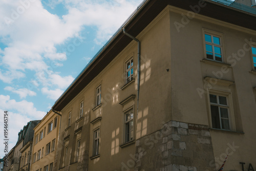 Old European building facade with classic windows and blue sky with clouds