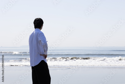 海を眺める男性の後ろ姿