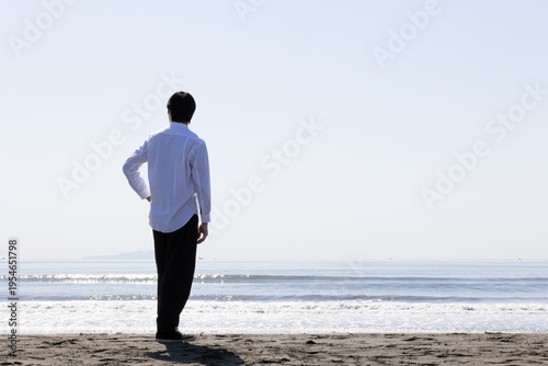 海を眺める男性の後ろ姿