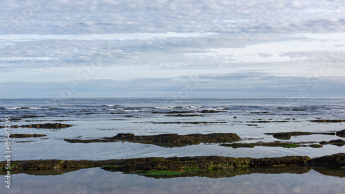 Small waves breaking over the exposed Devonian Sandstone during a retreating tide at East Haven Beach on the East Coast of Scotland.