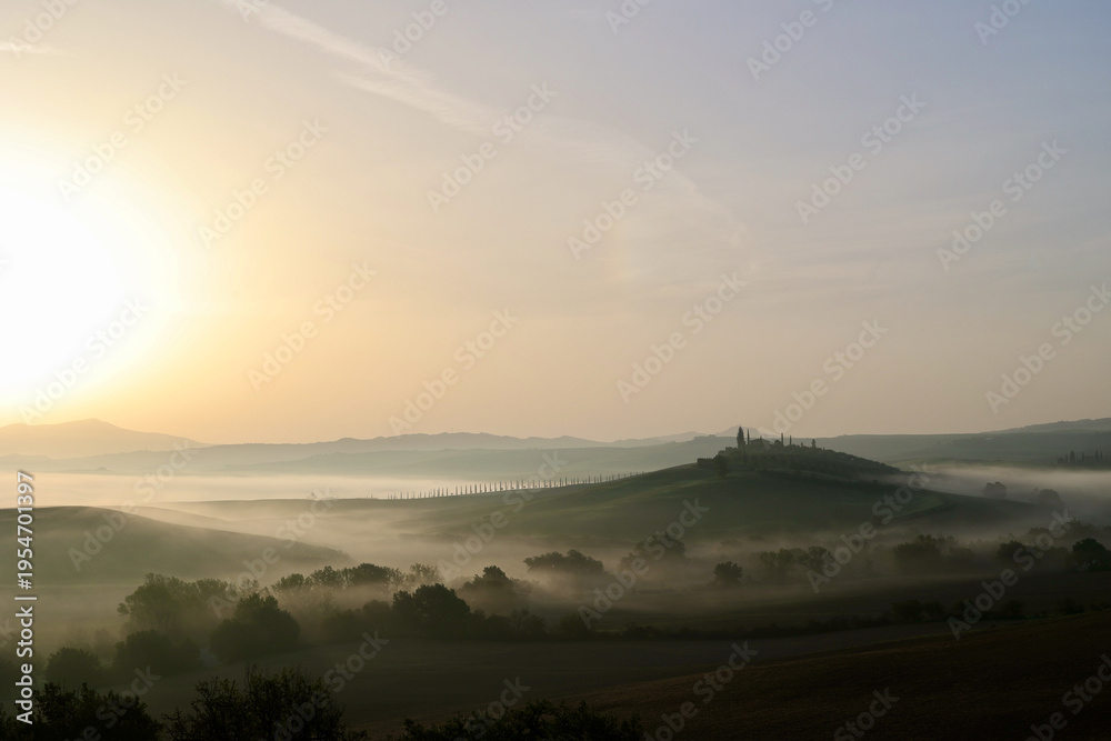 Fototapeta premium Autumn Sunrise over Misty Hills in the Province of Siena, Tuscany, Italy