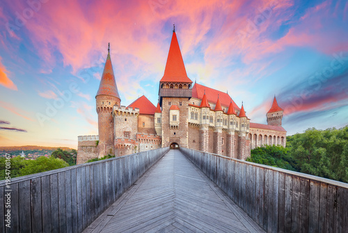 Breathtaking evening view of Hunyad Castle (Corvin's Castle) with wooden bridge at sunset .