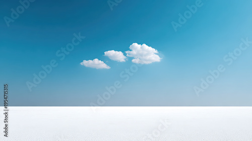 Bright blue sky with three small clouds over vast white salt flat landscape