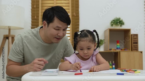 father and child girl drawing and painting with colorful oil pastels on paper at home