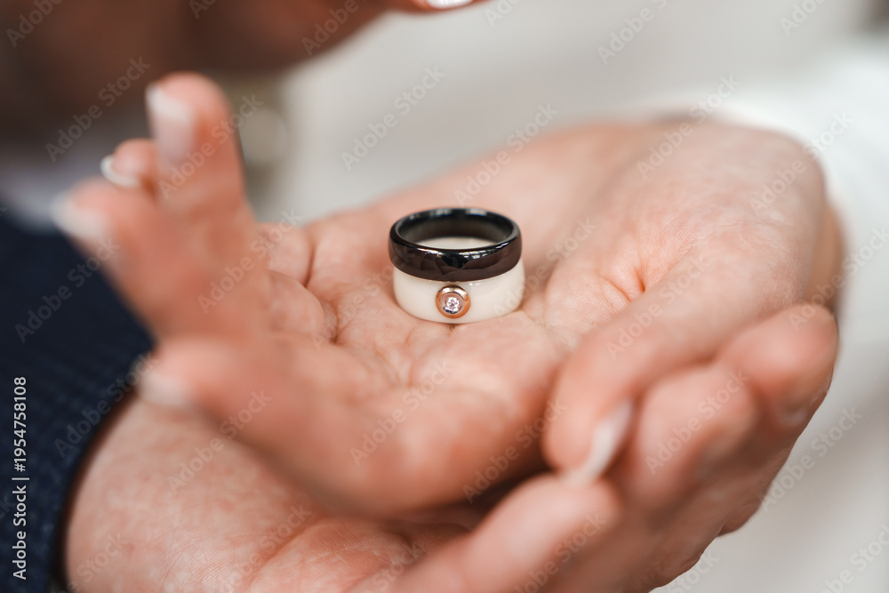Fototapeta premium Couple exchanges wedding rings during ceremony in bright setting