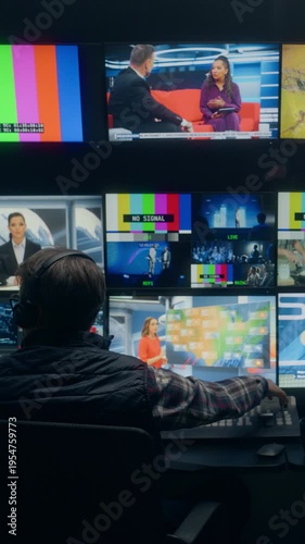 Vertical Screen. Backstage Tv Station Production Control Room With Male Operator Managing Live News Broadcasting, Switching Channel Feeds and Monitoring Anchor Segments Across Studio Screens.